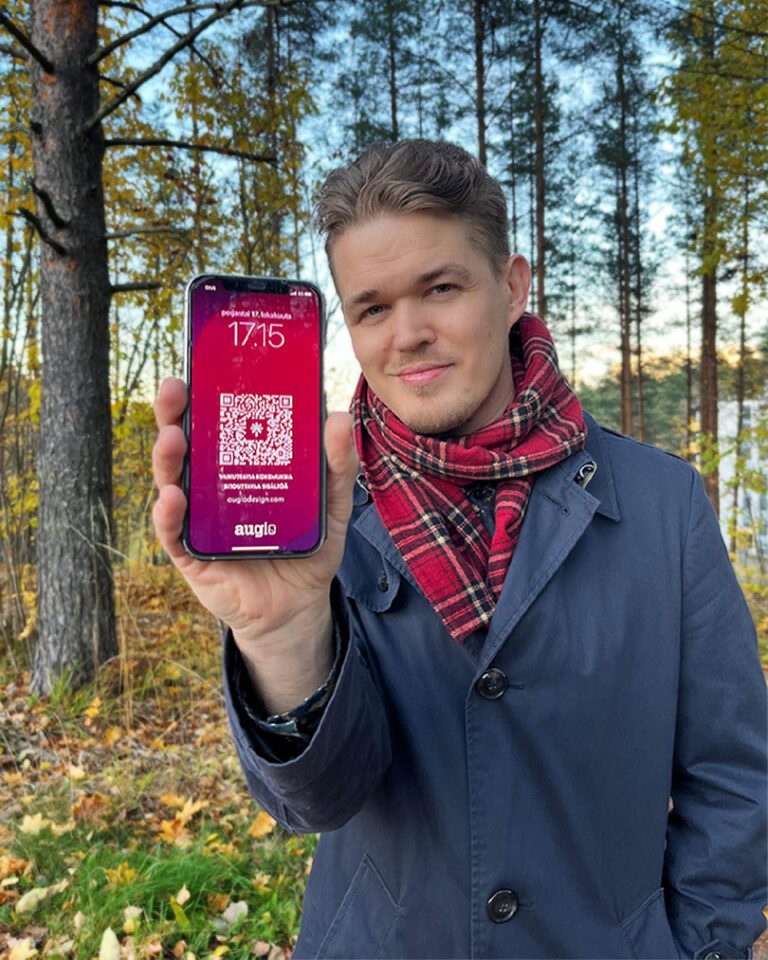 janne autio yrittäjä esittelee puhelimen taustakuva-käyntikorttia jossa on qr-koodi